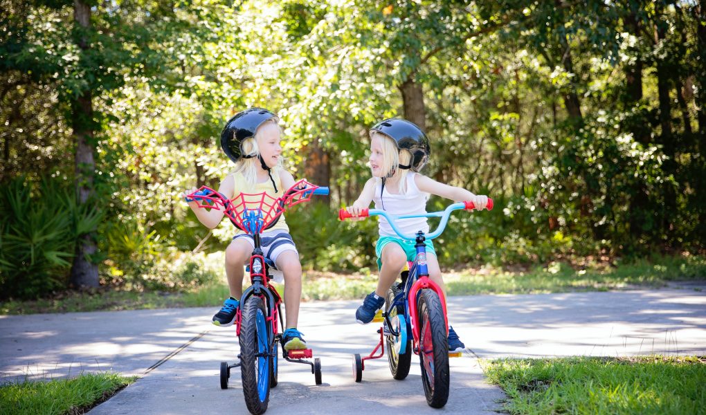 nyári gyerektevékenységek, két kislány biciklizik
